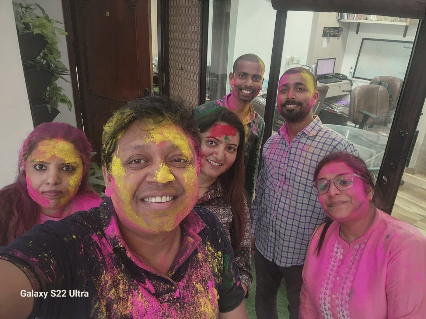 Holi at the office, faces covered in colour