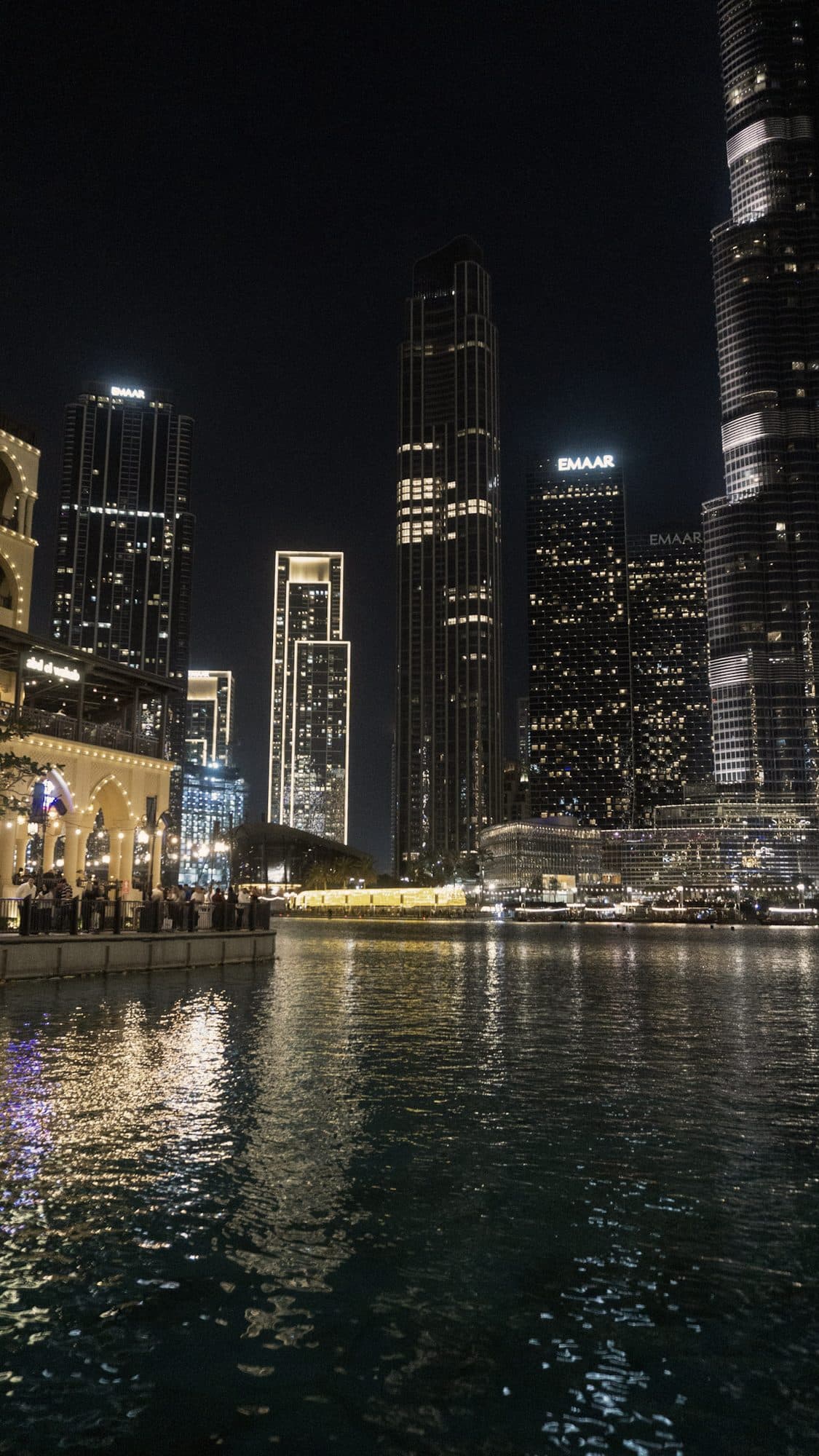 Downtown Dubai towers lit at night above the water