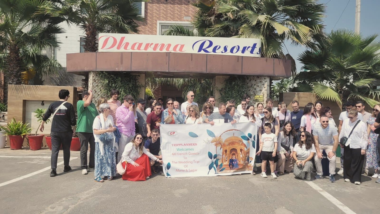 A corporate group outside Dharma Resort with their banner
