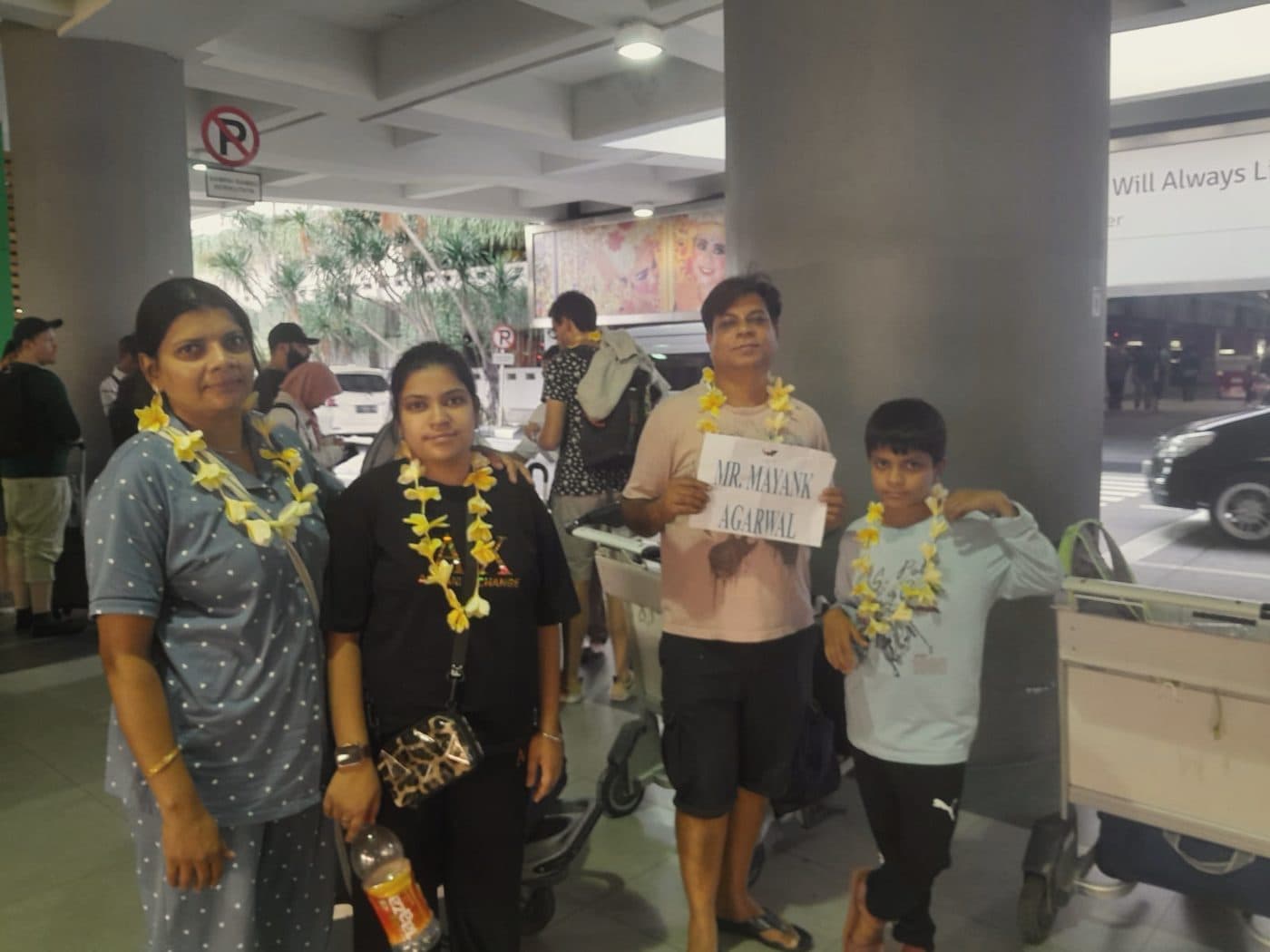A family garlanded on arrival