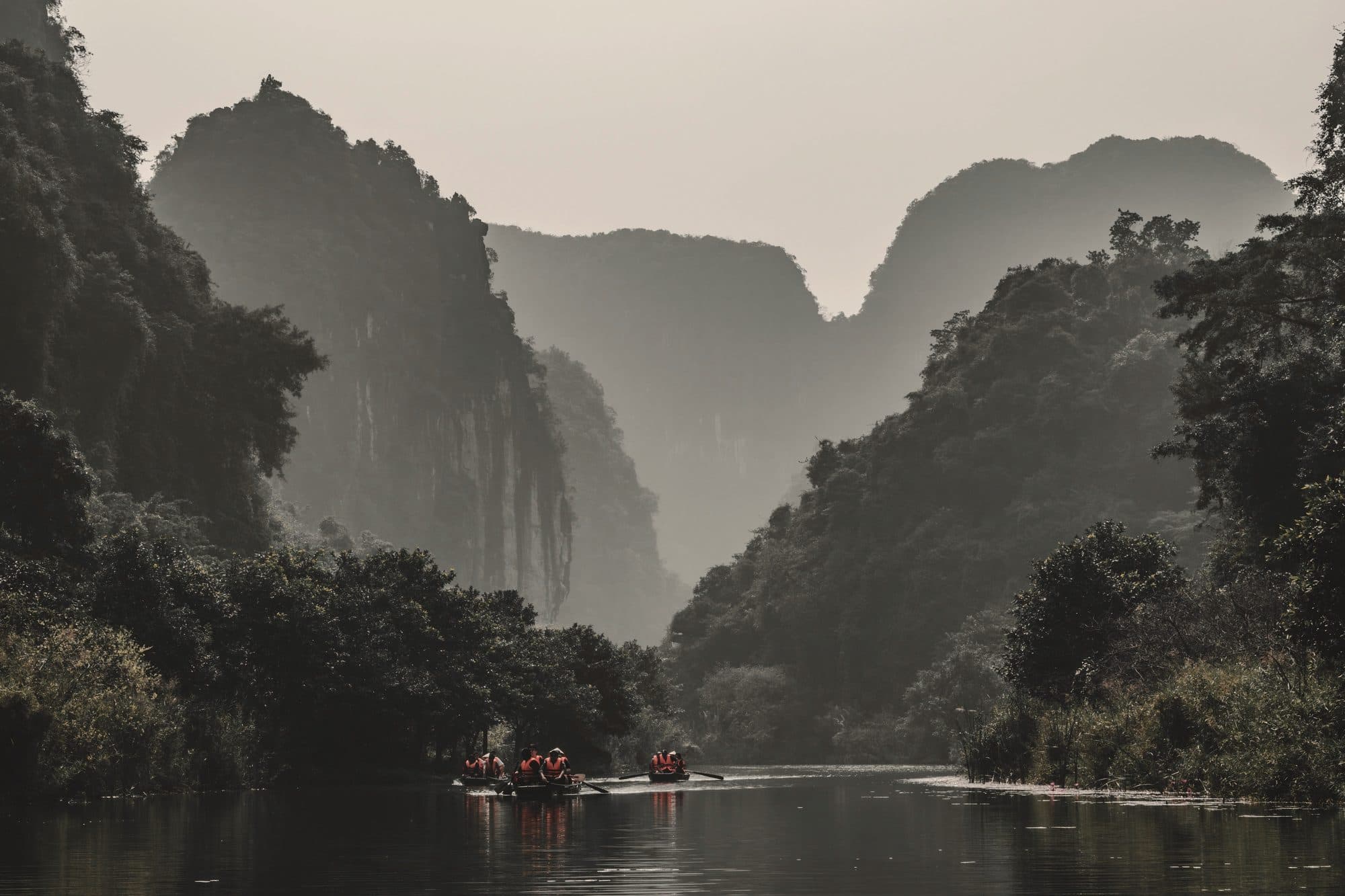 Rowing boats on the river between limestone karsts at Trang An, Vietnam