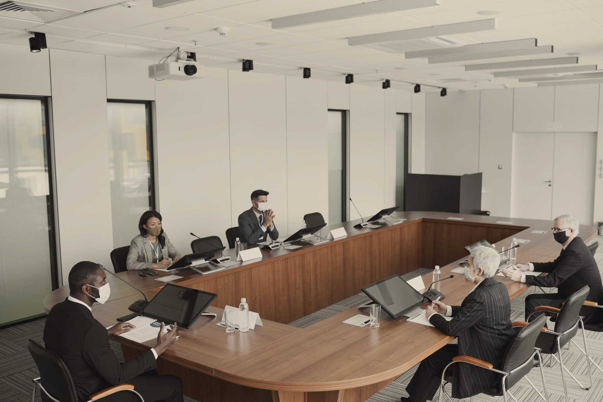 A leadership meeting around a long boardroom table